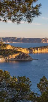 Scenic coastal view with blue ocean and golden cliffs at sunset.