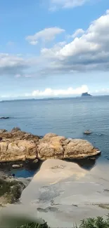 Coastal landscape with rocks and blue sky.