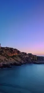 Serene lighthouse overlooking a coastal sunset scene with blue and purple skies.