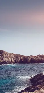 Serene coastal view with ocean and cliffs during sunset.