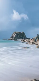 Serene coastal rock beach with dramatic sky and ocean waves.