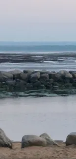 Tranquil coastal landscape with rocks and sea.