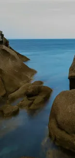 Serene coastal view with blue ocean and rocks.