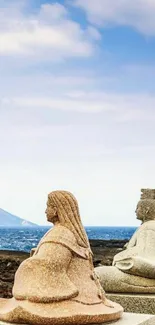 Stone sculptures by the sea under a blue sky.