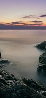 Serene sunset over rocky coastal waters.