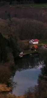 Serene countryside lake with houses and trees.