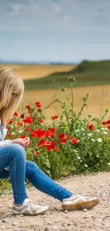 Woman sitting by vibrant flowers in serene countryside.