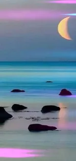 Crescent moon reflecting on a tranquil ocean with rocks.