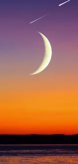 Crescent moon over a vibrant orange sunset and ocean.