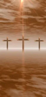 A serene mobile wallpaper of three crosses in a misty, sepia-toned landscape.