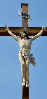 Crucifix under a serene blue sky, symbolizing peace.