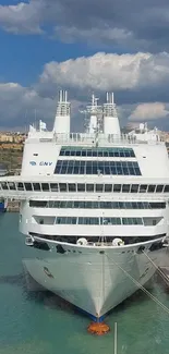 Cruise ship docked under a blue sky.