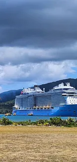 A majestic cruise ship on tranquil blue ocean near a lush tropical island.