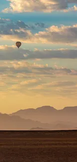 Serene desert scene with a hot air balloon in the sky.