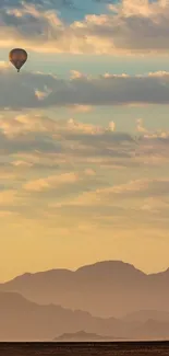 Hot air balloon gliding over mountains at sunrise