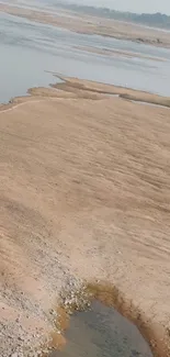 Desert landscape with beige sands and calm water.