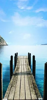 Wooden dock extending into serene blue waters under a clear sky.