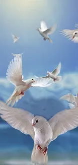 White doves flying in a blue sky over an ocean.