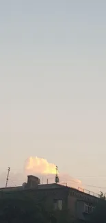 An evening sky with gradient colors over a rooftop silhouetted by sunset clouds.