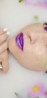 Woman in milk bath with flowers and purple makeup.