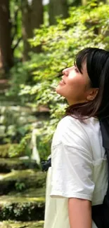 Woman enjoying nature on a forest pathway with lush greenery.