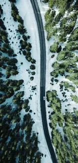 Aerial view of a serene forest road surrounded by lush green trees and snow.