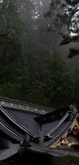 Traditional Japanese temple roof amidst misty forest.