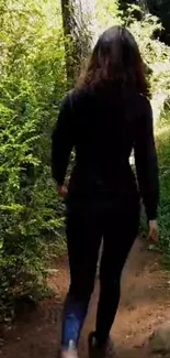 Person walking on a lush forest trail surrounded by greenery.