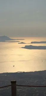 Golden sunset over a serene ocean with distant islands.