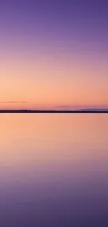 Beautiful tranquil purple and pink gradient over a calm lake at sunset.