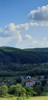 Scenic view of green hills with blue sky and clouds, perfect for peaceful ambiance.