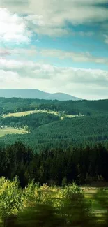 Serene green landscape wallpaper with lush forest and clear sky.