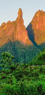 Lush green mountains at sunrise with clear blue sky.