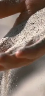 Close-up of sand flowing through hand, creating a serene and natural texture.