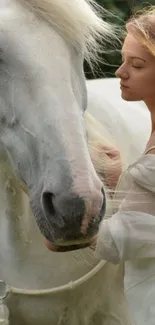 Woman gently caressing a white horse in nature