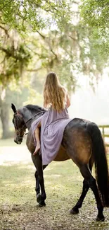 Woman riding a horse on a wooded path with soft sunlight filtering through trees.