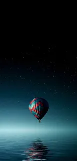 Hot air balloon over ocean at night with stars.