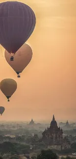 Hot air balloons at sunrise over ancient landscape.