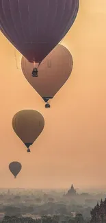 Hot air balloons at sunset over temples and landscape.