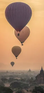 Hot air balloons gracefully float against a sunset sky over a distant pagoda.