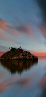 Serene island at sunset with calm reflections and a vibrant sky.