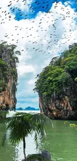 Tropical island scene with towering rocks and lush greenery over calm waters.