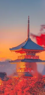 Japanese temple with orange sunset sky in background.