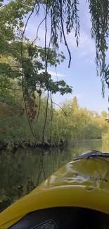 Yellow kayak gliding through a lush, green river tunnel in nature.