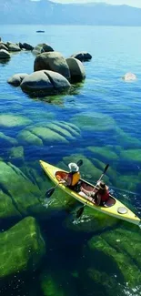 A calming view of kayakers in clear waters with rocks and blue skies.