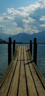 Serene wooden dock extending into a calm lake under blue sky.