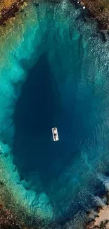 Aerial view of a peaceful teal lake with a single boat in the center.