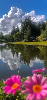 Serene lake with flower foreground and blue sky in mobile wallpaper.