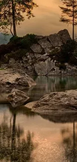 Serene lake with sunset reflecting in calm waters and rocky landscape.