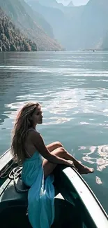 Woman in a blue dress sitting on a boat in a scenic mountain lake view.